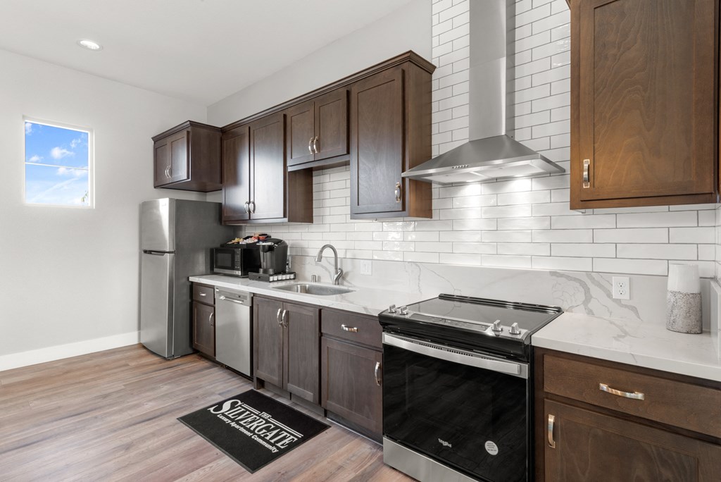 a kitchen with dark wood cabinets and white countertops