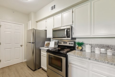 a kitchen with stainless steel appliances and granite counter tops