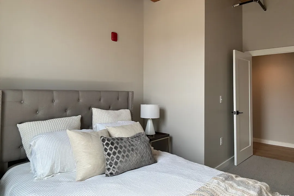 a bedroom with a bed and a door to a closet