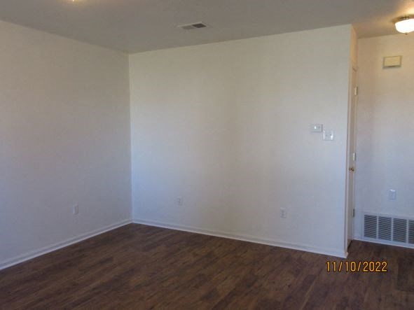 an empty living room with white walls and wooden floors