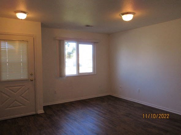 an empty living room with a door and a window
