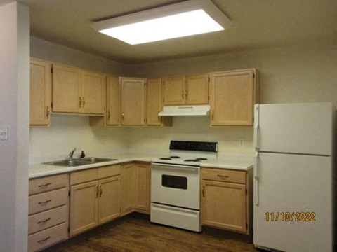 a kitchen with white appliances and wooden cabinets