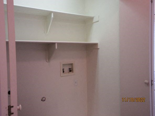 an empty bathroom with a light on the wall