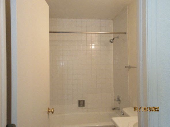 a white bathroom with a shower and a sink