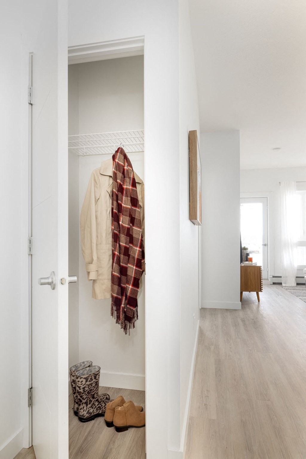 a hallway with a white door and a coat hanging on the wall
