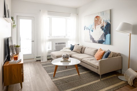 a living room with a couch and a coffee table and a painting on the wall