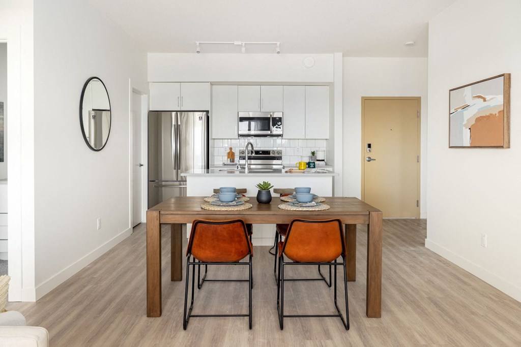 a dining room and kitchen with a table and chairs