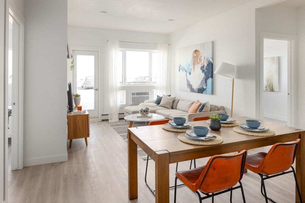 a living room and dining room with a table and chairs