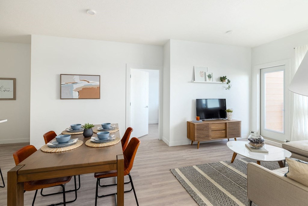 a living room with a dining room table and a television