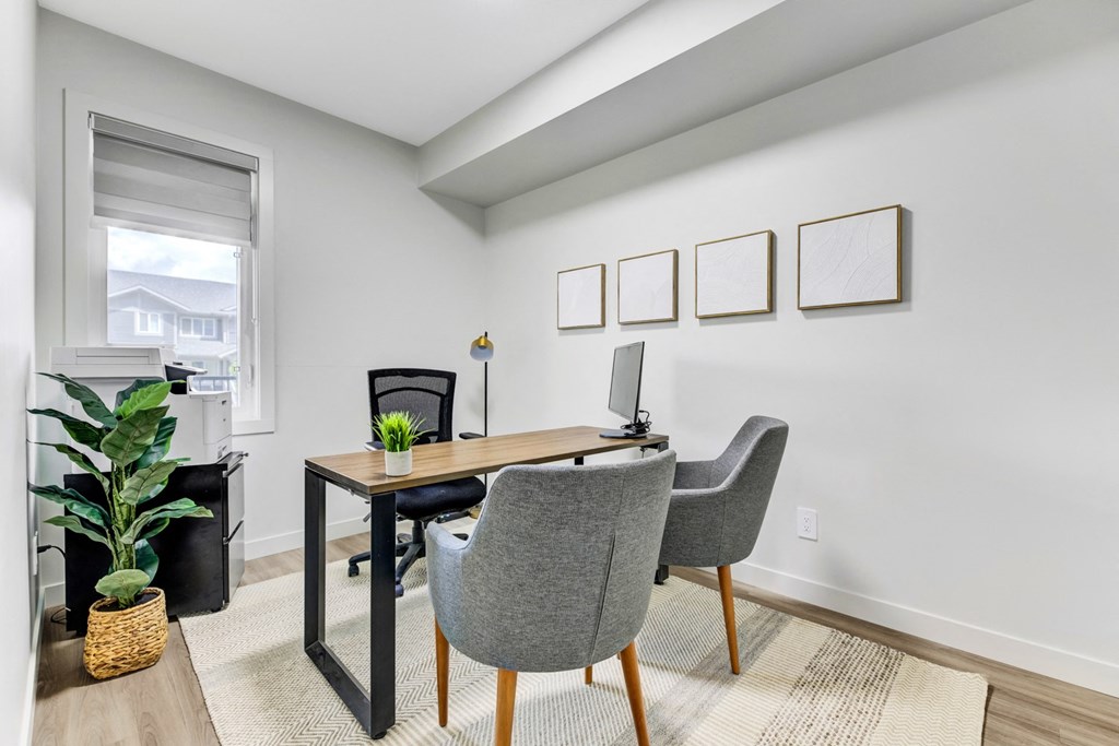 an office with a desk and chairs and a window