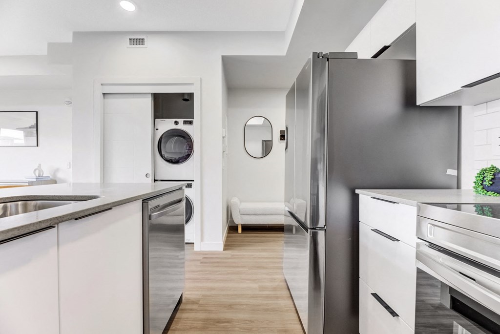 a modern kitchen with stainless steel appliances and white cabinets