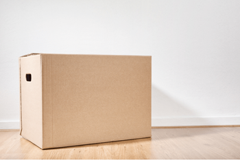 a cardboard box sitting on a floor next to a white wall