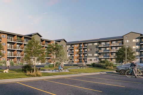 A modern apartment complex with a parking lot in front.