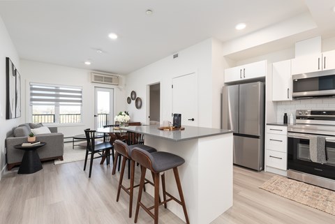 A modern kitchen with a bar area and a dining table.