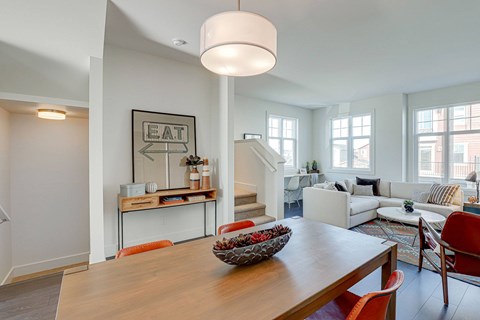 A modern dining room with a wooden table and chairs.