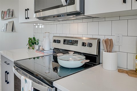 A modern kitchen with a stove top oven and a microwave above it.