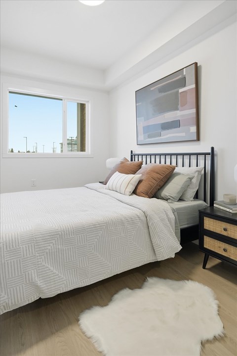 A bedroom with a large bed and a painting on the wall.