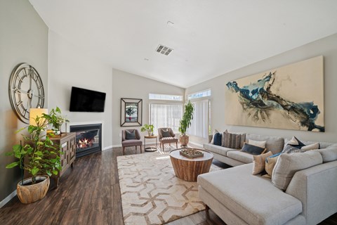 A living room with a fireplace, a couch, and a painting on the wall.