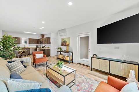 A living room with a glass coffee table and a couch with a striped pillow.