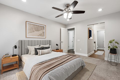 A bedroom with a large bed and a ceiling fan.