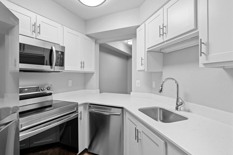 A kitchen with white cabinets and stainless steel appliances.