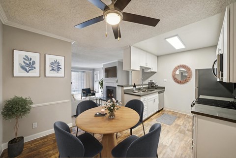 A dining room with a table and chairs and a ceiling fan.