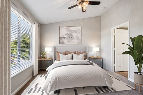 A bedroom with a large bed and a ceiling fan.