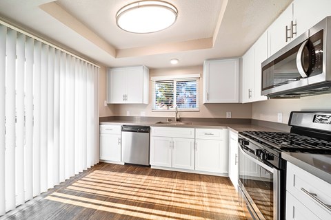 A kitchen with white cabinets and a black stove top oven.