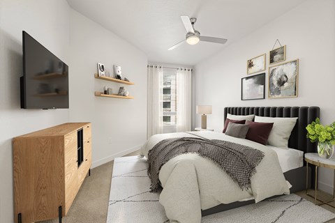A bedroom with a large bed and a flat screen TV mounted on the wall.