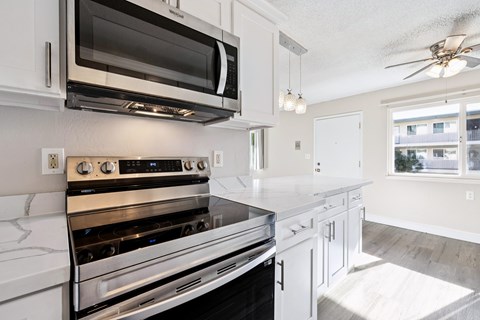 A modern kitchen with white cabinets and stainless steel appliances.