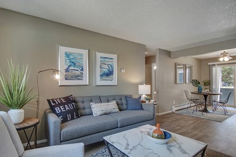 A living room with a grey couch and a coffee table.