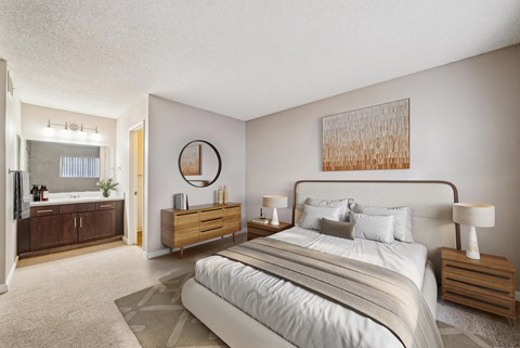 A bedroom with a large bed, nightstands, and a painting on the wall.