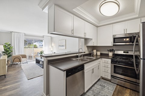 A modern kitchen with stainless steel appliances and white cabinets.