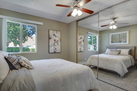 a bedroom with two beds and a ceiling fan