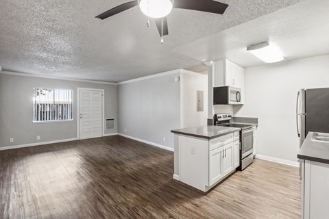 A kitchen with white cabinets and a wooden floor.