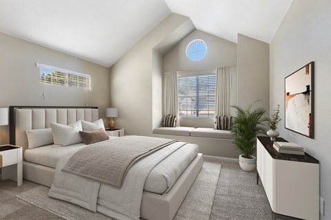 A bedroom with a large bed and a window with blinds.