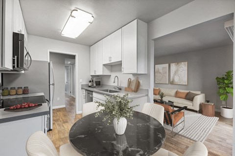 A modern kitchen with a black table and white chairs.