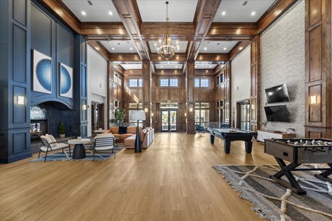 A spacious living room with a pool table and a fireplace.