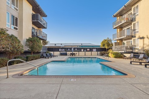 A swimming pool in a residential area with a building in the background.