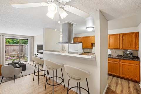 A kitchen with a white ceiling fan and a white counter top.