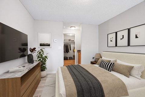A bedroom with a large bed and a TV on the wall.
