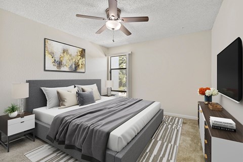 A bedroom with a large bed and a ceiling fan.