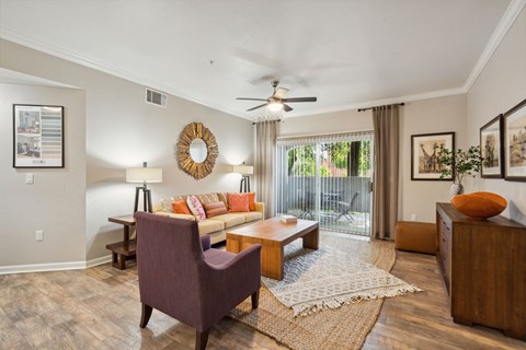 A living room with a purple chair and a wooden coffee table.