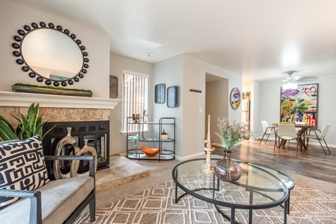 A living room with a fireplace, a sofa, a coffee table, and a painting on the wall.