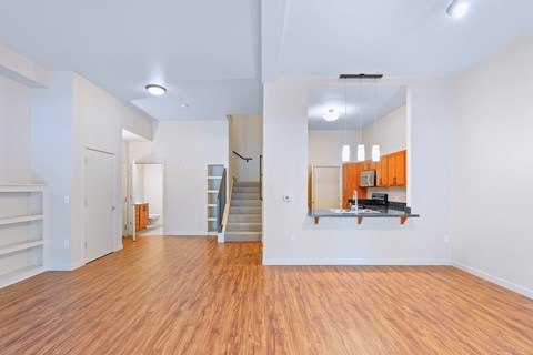 A spacious room with wooden floors and white walls.