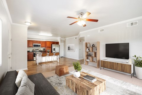 A living room with a brown couch and a ceiling fan.