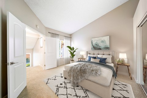 A bedroom with a large bed and a painting on the wall.