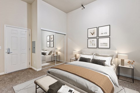 A bedroom with a large bed and a mirror on the wall.