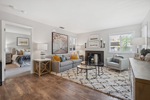 A living room with a grey couch, a coffee table, and a painting on the wall.