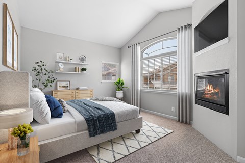 A bedroom with a large bed and a fireplace.